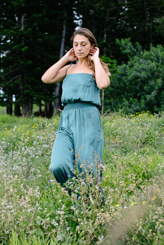 Effortless pull-on jumpsuit that features a smocked waist with a loose fit throughout the rest of the garment. Dyed to a muted teal blue.